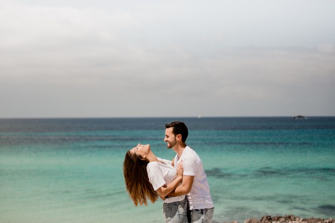 Laughing lovers hugging on beach