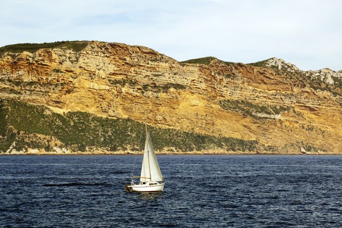 sailboat in sea and beautiful rocks