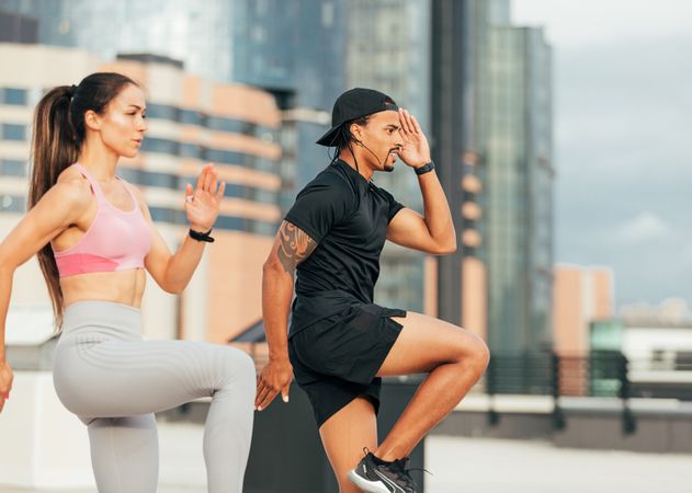 Fit man and woman working out on roof top