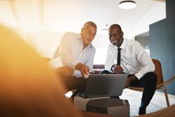 Two men in business attire working together