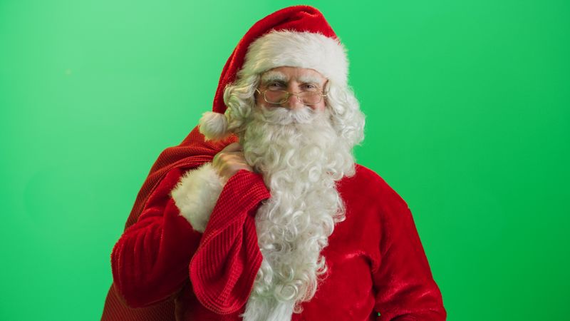 Studio Shot Isolated Mockup Template: Jolly Santa Claus Standing On Green Screen Chromakey Background With Hands Crossed, Looks At the Camera. Christmas, New Year, Holiday Celebration
