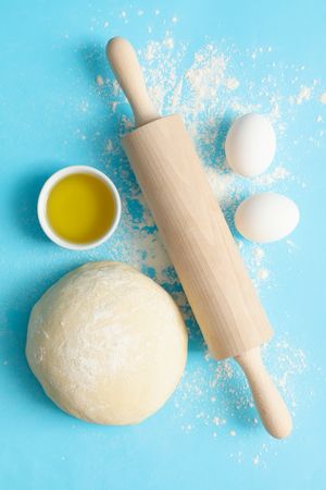 Concept for baking with dough on blue background