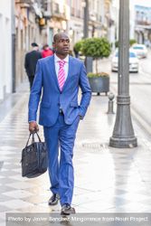 Male in business attire strolling down European street bE3Vl5