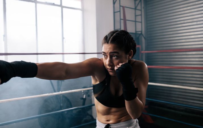 Female boxer training working out in the ring