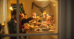 Happy Family Gather at Home for a Traditional Christmas Dinner with a Turkey Roast.