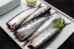 Raw fish without heads on light plate