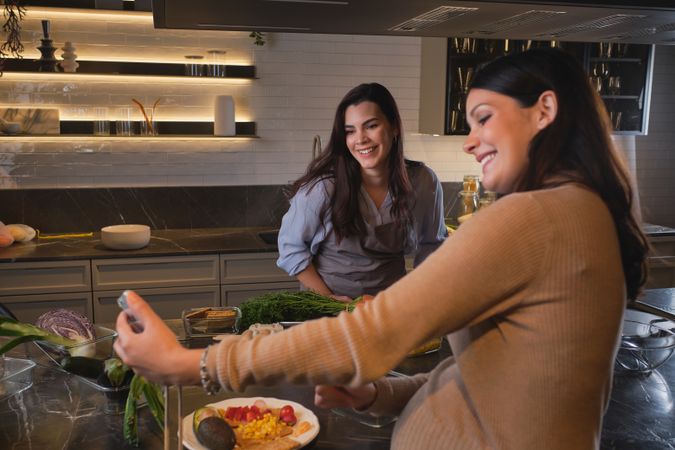 Women talking selfie and cooking in kitchen