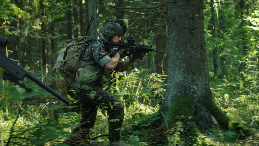 Squad of Fully Equipped Soldiers in Camouflage with Rifles in Firing Position.