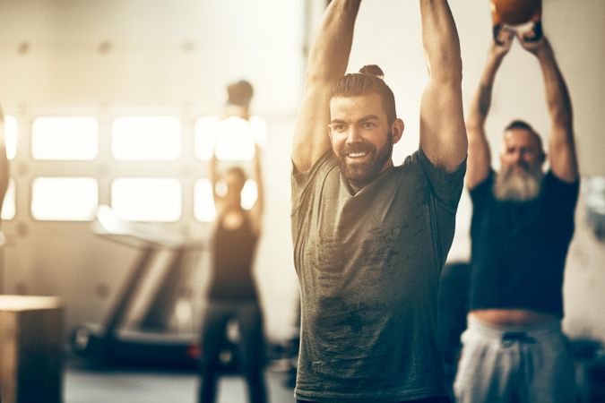 Happy man in workout class with kettlebells