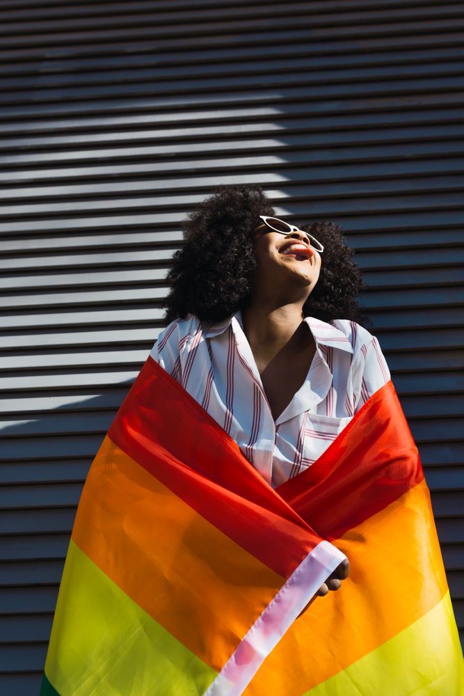 Smiling woman posing happily with the LGBT flag
