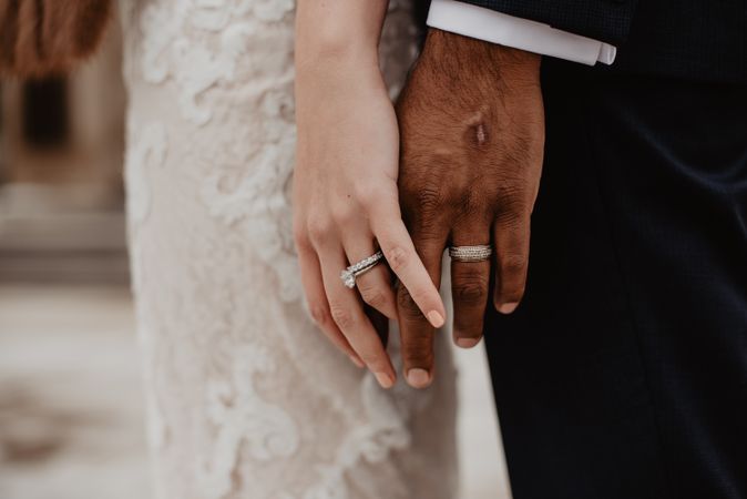 Cropped image of bride's and groom's hand with wedding rings