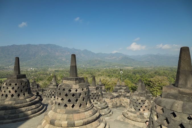 Borobudur Buddhist temple and bell-shaped stupas, surrounded by mountains in Indonesia