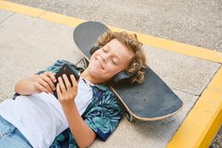 Cheerful boy with skateboard on street