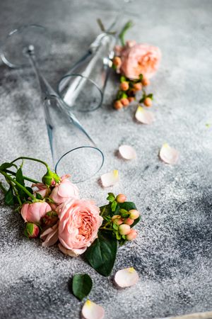 Pink flowers on grey table with champagne flutes