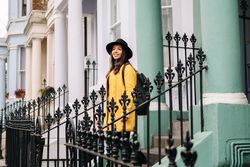 Cheerful woman standing in stairs in typical london buildings