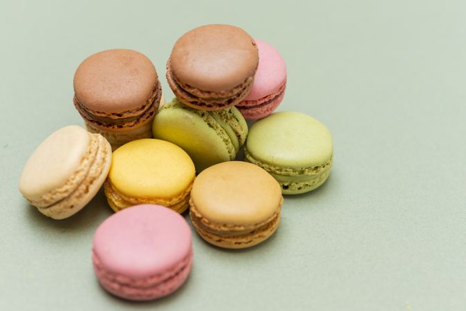 Looking down at colorful macaroons scattered on a green table