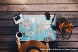 Young woman planning vacation using a world map, compass and other travel accessories 0Pkpvb