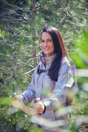 Smiling Hispanic woman with backpack in nature