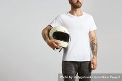 Tattooed man in light t-shirt holding motorcycle helmet 4BM9W5