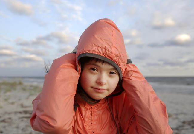 Young child wearing winter jacket on a cloudy beach day