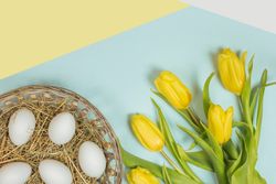 Fresh yellow flowers and easter eggs with green leaves