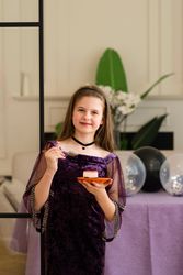 Girl smiling while eating cake at birthday party.