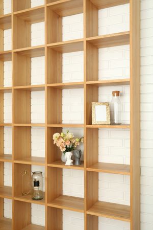 Wooden shelves with different items against brick wall