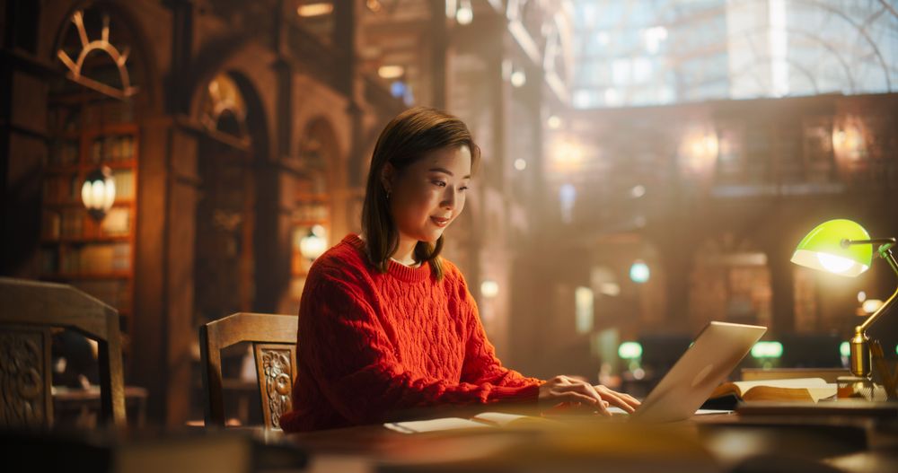 Focused Japanese Female Student Studying in a Classic Library