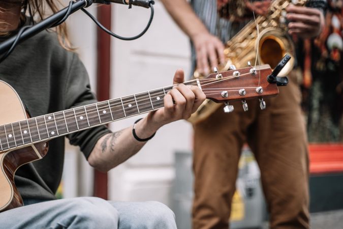 Male saxophonist and guitarist playing in the street