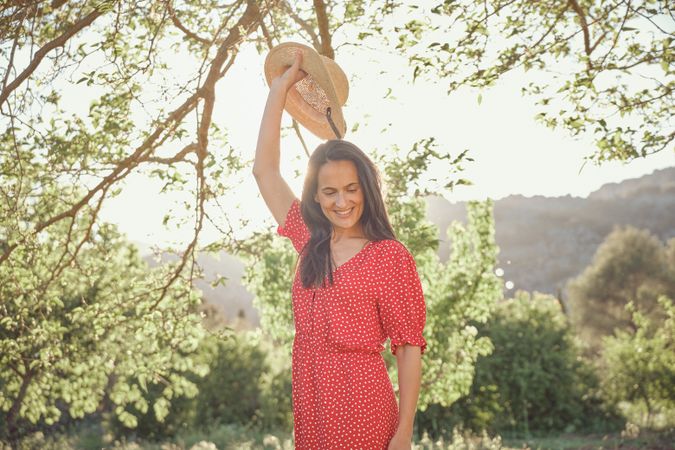 Smiling woman with hat in park