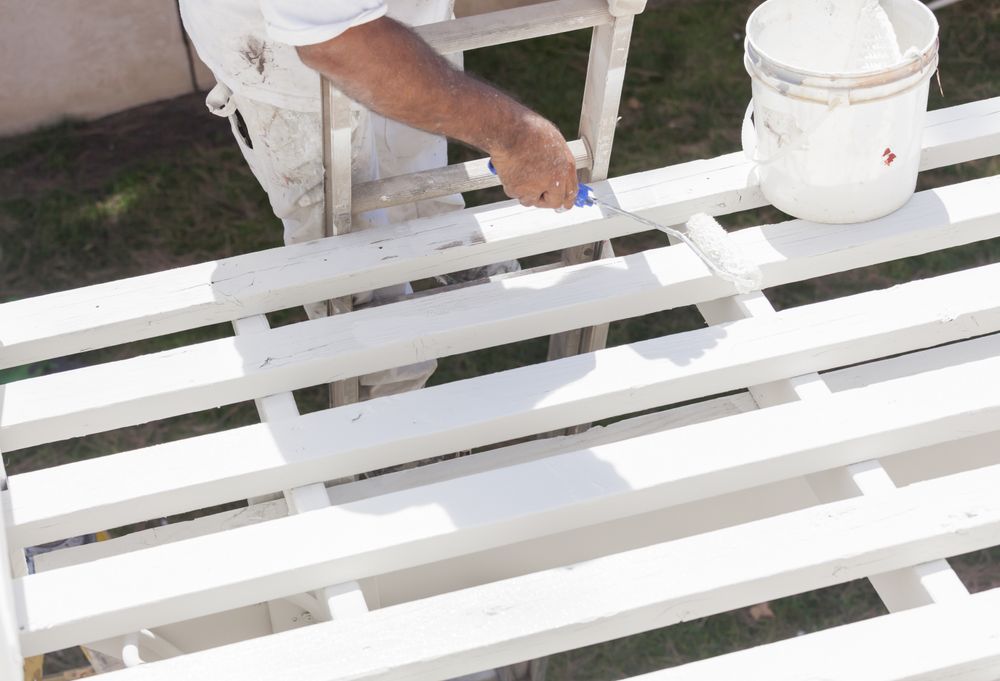 Painter Rolling Paint Onto Top of Patio Cover
