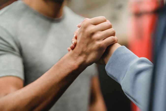 Cropped image of two people greeting each other with traditional African handshake
