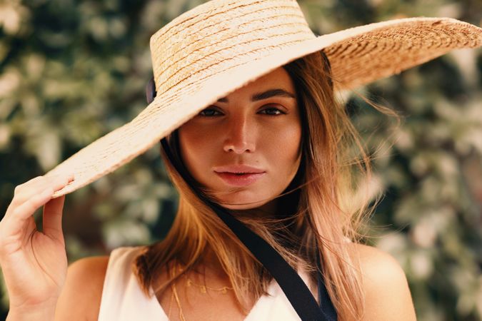 Portrait of woman with a tilted straw hat