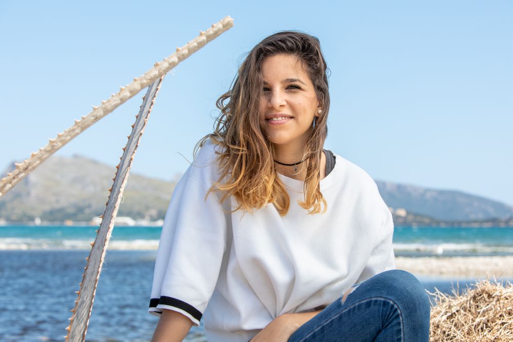 Young woman sitting near dried plants