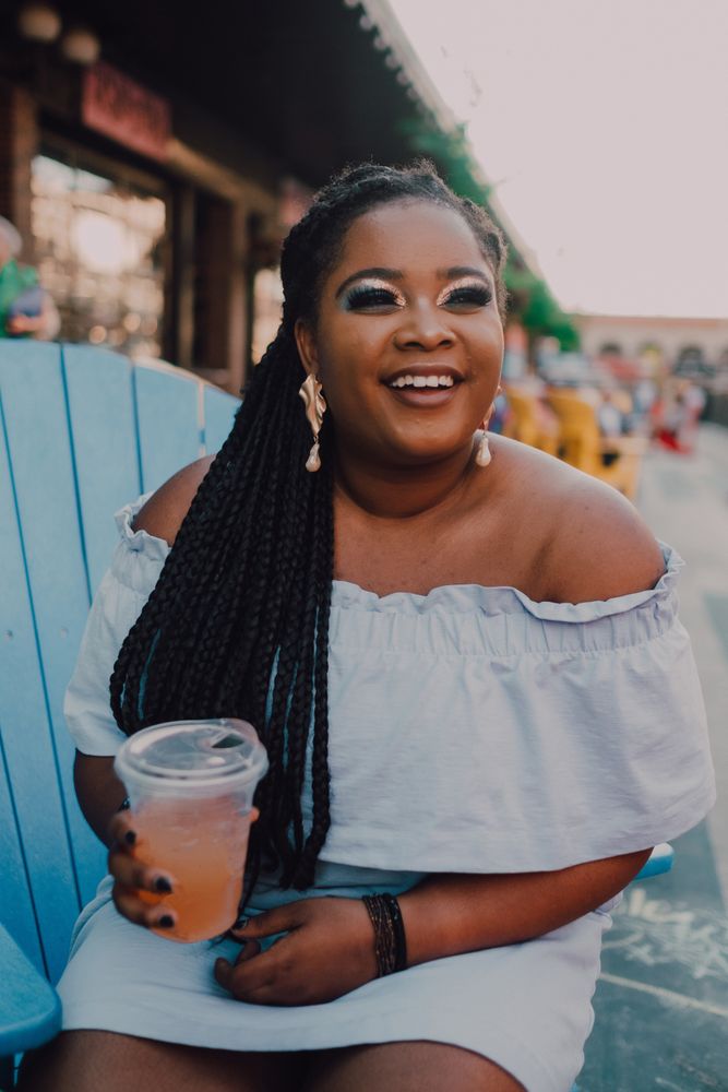 Black modern woman drinking cold beverage at coffee shop