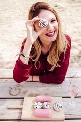 Woman looking through hole of donut