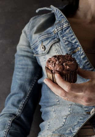 Crop woman with chocolate banana muffin