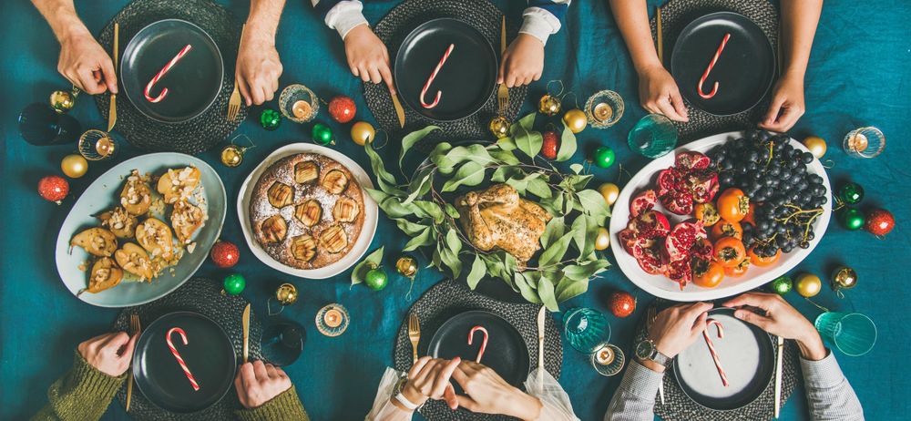 Christmas or New Year party dinner at festive table top view, wide composition