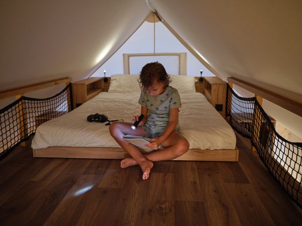 Boy reading notebook with flashlight