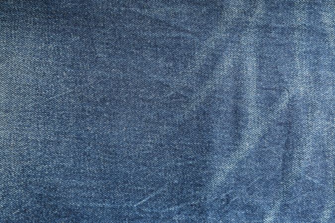 Texture of blue jeans as background, space for text