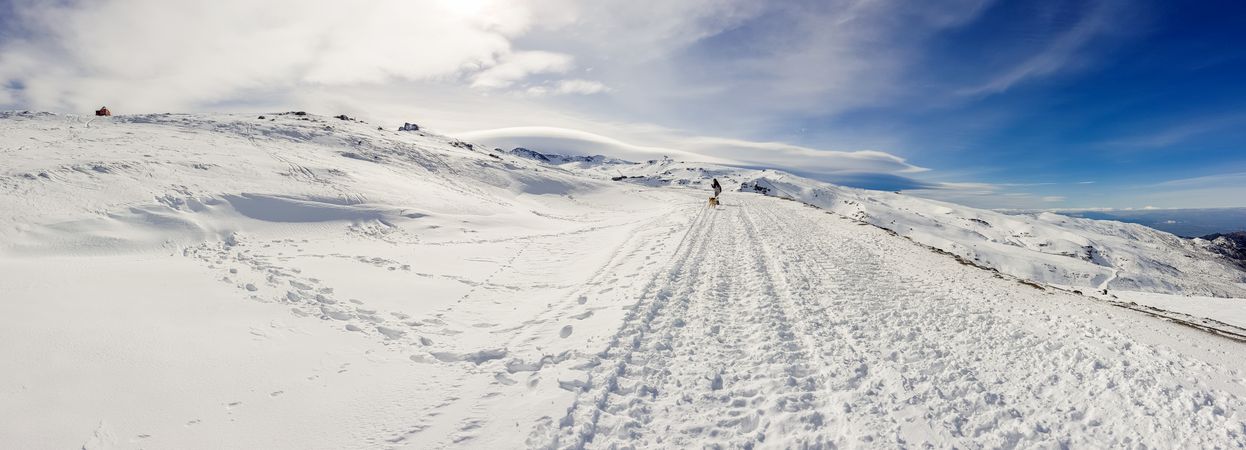 Snowboarder in distance of ski resort of Sierra Nevada in winter