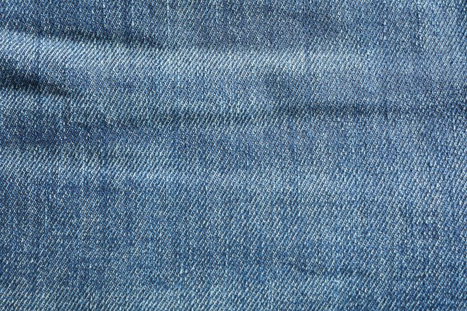 Texture of blue jeans as background, space for text