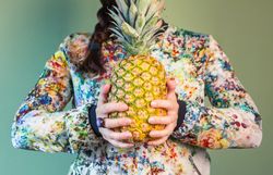 Woman holding pineapple between her hands