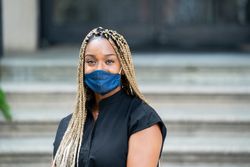 Portrait of medical worker in mask and black scrubs looking at camera