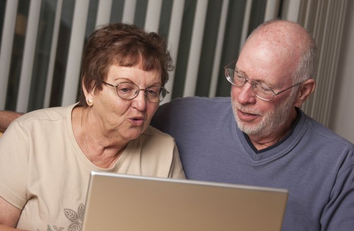 Smiling Mature Adult Couple Having Fun on the Computer