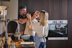 Happy family throwing dough at one other while baking at home