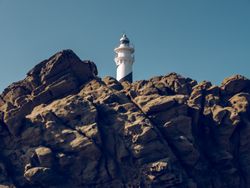 Lighthouse located on rocks in sunlight