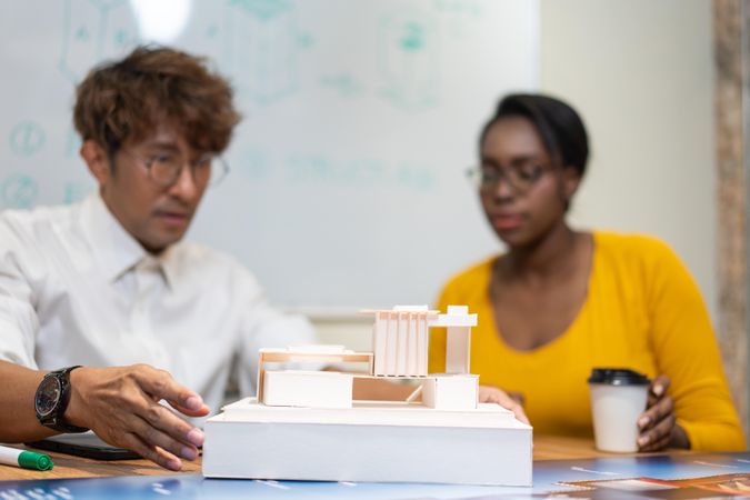 Two colleagues having meeting looking at model of building