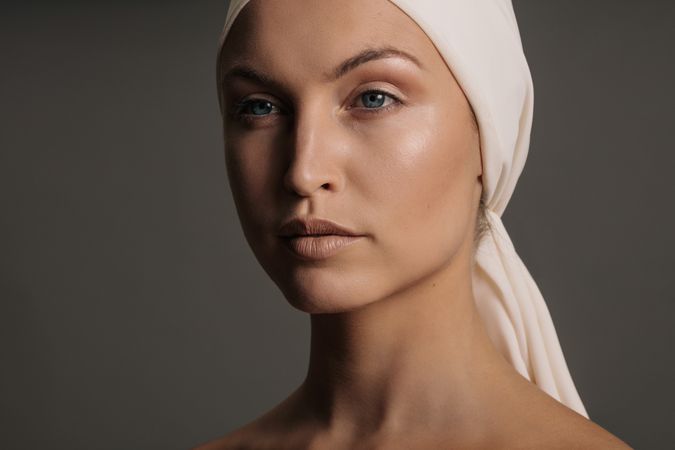 Blonde model with fresh face in head scarf in grey studio shoot