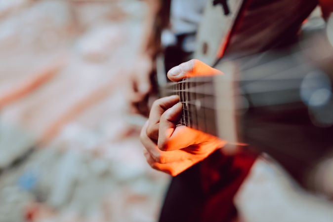 Man clamping strings on guitar neck